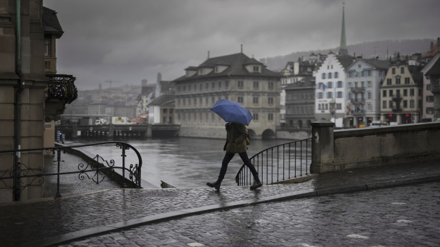 A woman crosses Muensterbridge over the river Limmat, on an autumnal day in Zurich, Switzerland, 21 November 2023